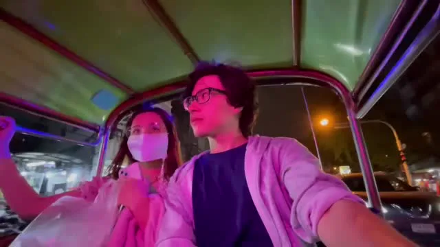 An on-camera HIMR participant beside a masked participant in an open-sided vehicle at night